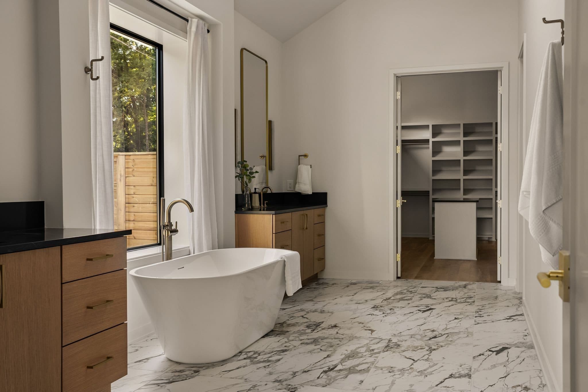 Bath with a freestanding soaking tub, marble look floors, and a walk in closet beyond at 4206B Belmont Park Terrace, Green Hills Nashville