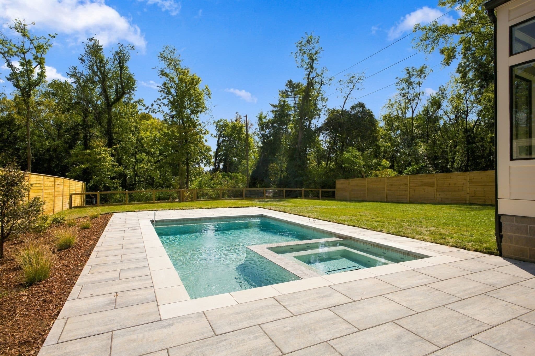 Pool with an integrated spa, a paver deck, and a fenced, tree lined backyard at 4206B Belmont Park Terrace, Green Hills Nashville