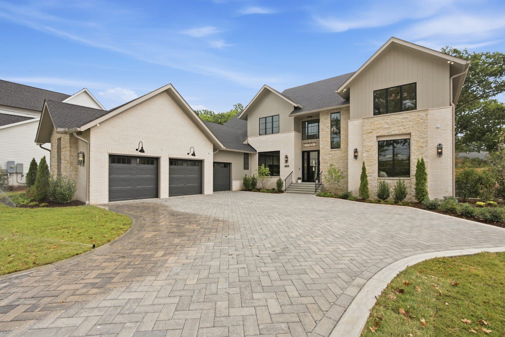 Front exterior of the new construction home with a paver motor court and three car garage at 3720 Benham Ave, one of the Green Hills homes for sale in Green Hills Nashville