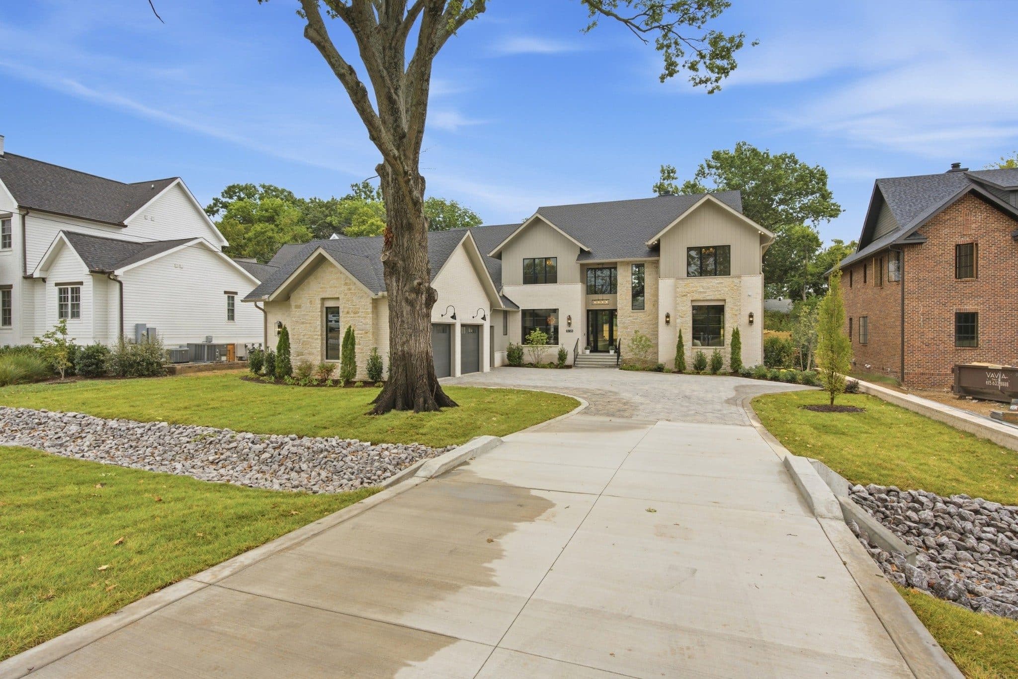 Front exterior seen from the street with the long driveway and a mature shade tree at 3720 Benham Ave, Green Hills Nashville