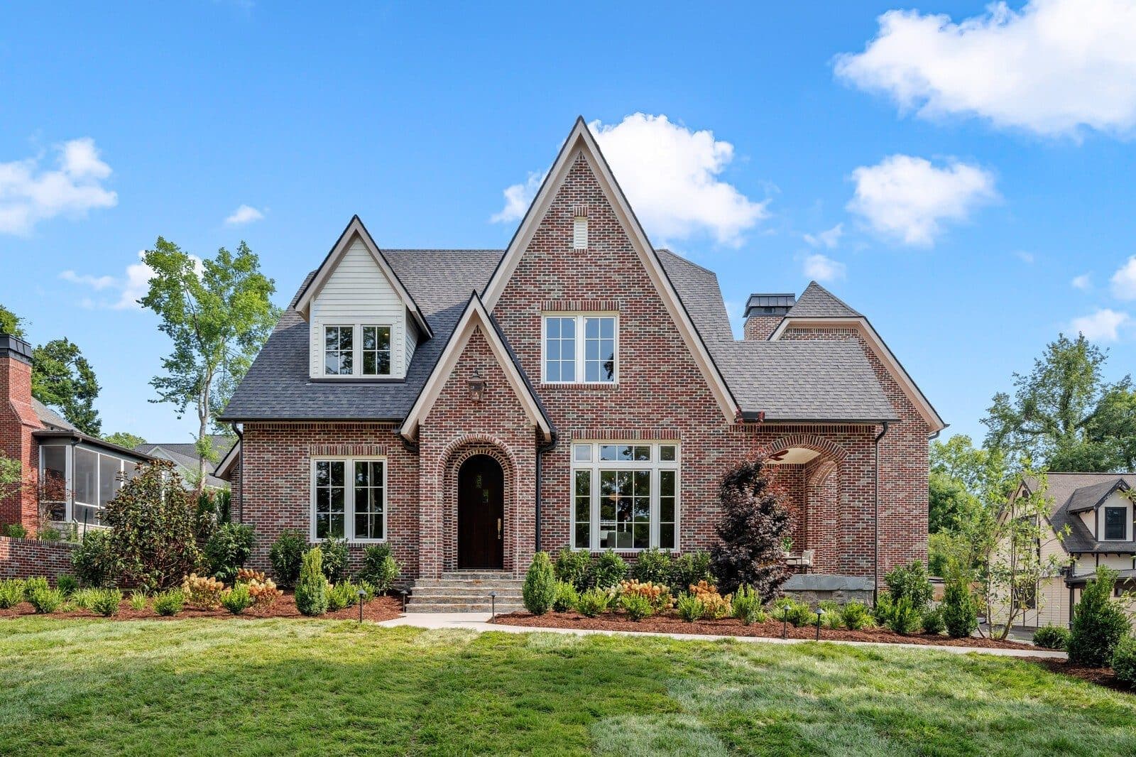 Front exterior of the brick Tudor style home with a steep gabled roofline at 1113 Glenwood Ave, one of the Green Hills homes for sale in Green Hills Nashville