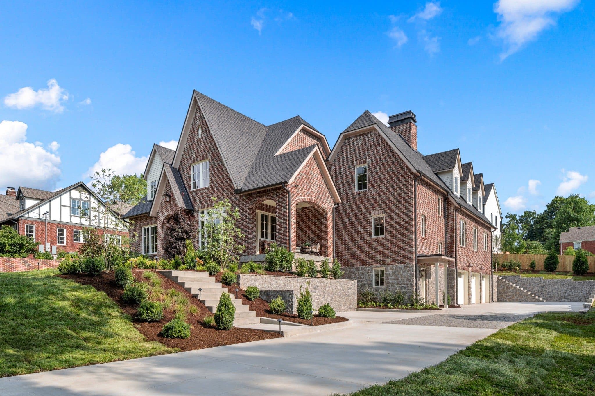 Side view of the brick home with the driveway leading back to the garage at 1113 Glenwood Ave, Green Hills Nashville