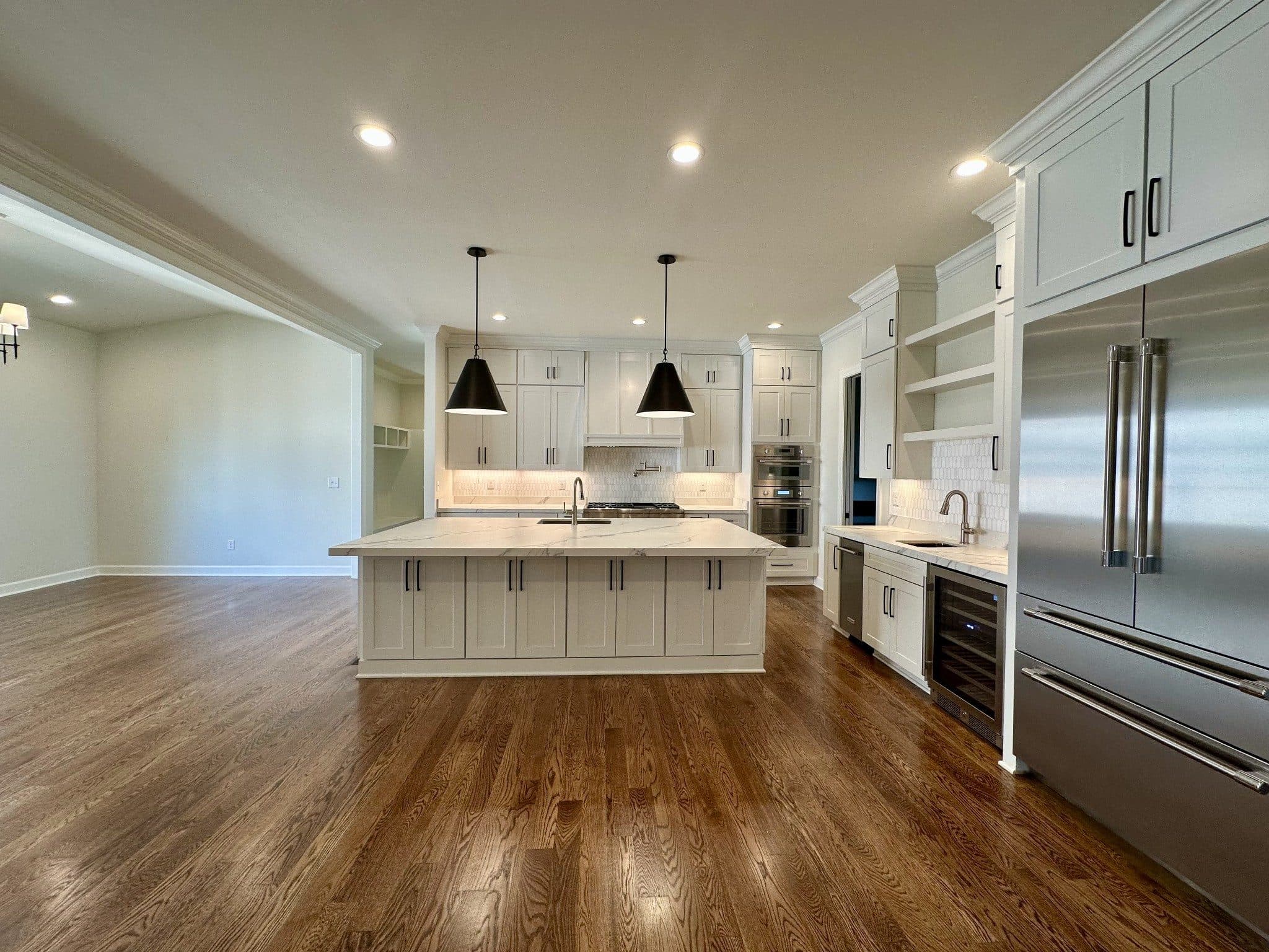 Kitchen with a white island, black pendant lights, and stainless appliances at 3300 Trimble Road, Green Hills Nashville