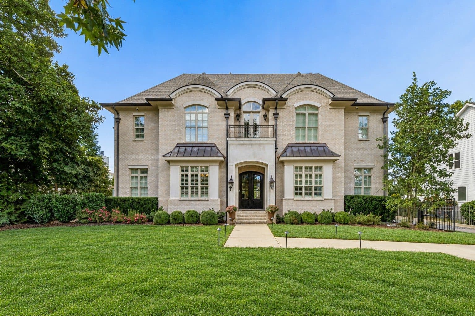 Front exterior of the light brick home with a manicured front lawn at 4019 Vailwood Drive, one of the Green Hills homes for sale in Green Hills Nashville