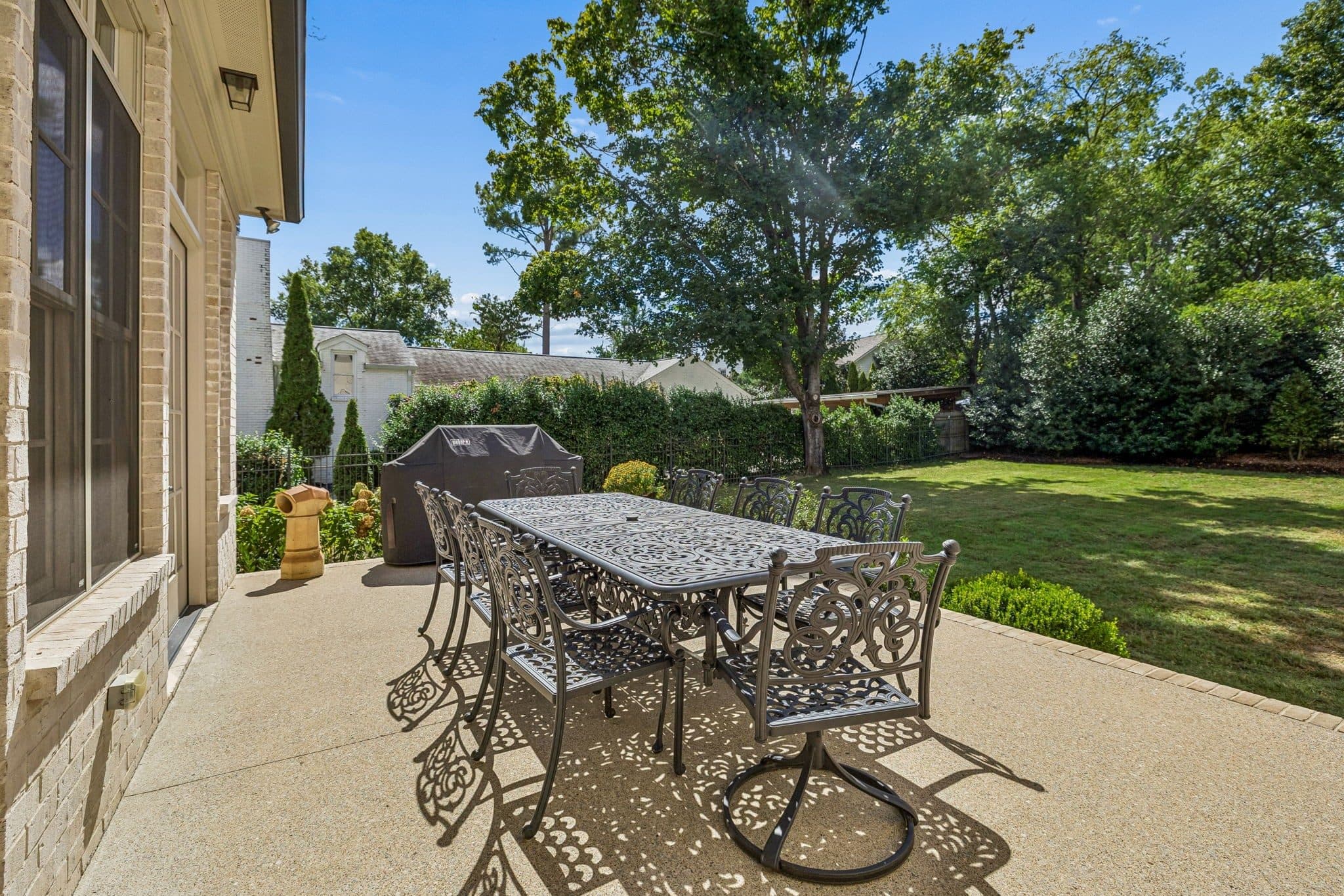 Patio dining area overlooking the fenced backyard lawn at 4019 Vailwood Drive, Green Hills Nashville