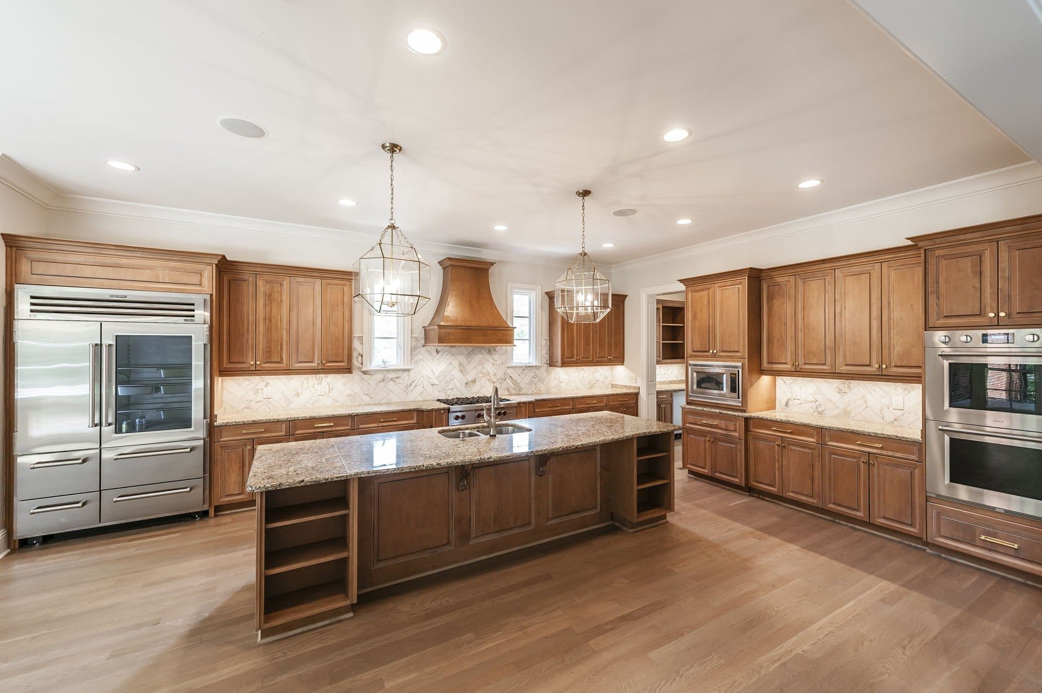 Kitchen with wood cabinetry, a large island, granite counters, and stainless appliances at 4301 Wallace Lane, Green Hills Nashville