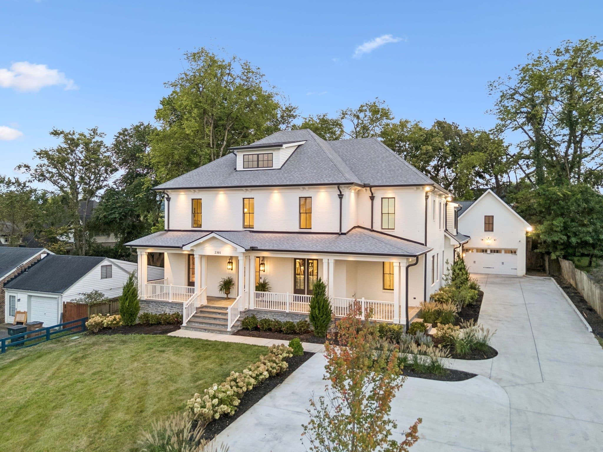 Front exterior of the white two story home with a full front porch and a detached garage at 2301 Warfield Lane, one of the Green Hills homes for sale in Green Hills Nashville